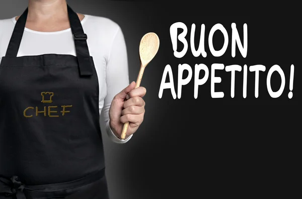 Buon appetito cook holding wooden spoon background — Stock Photo, Image