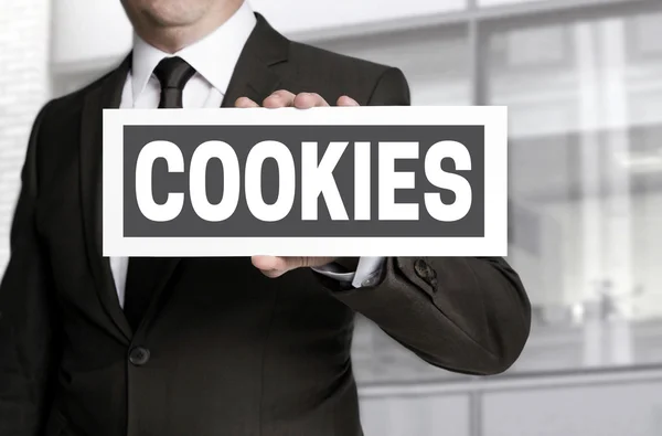 Cookies plate is held by businessman background — Stock Photo, Image