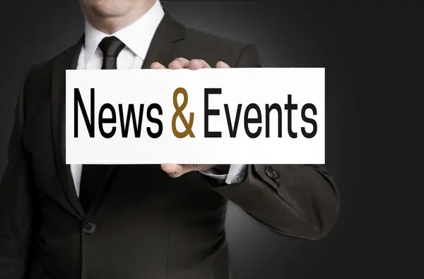 News and events sign is held by businessman — Stock Photo, Image