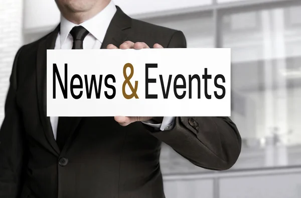 News and events sign is held by businessman — Stock Photo, Image