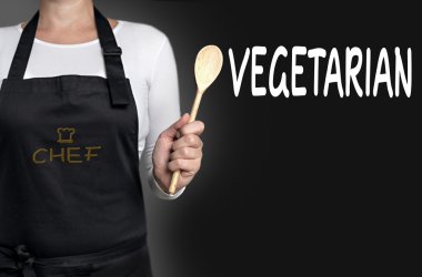 tahta kaşık arka planda tutan vejetaryen Şef