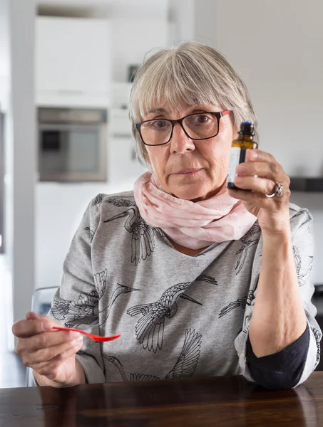 Senior woman drip medication on spoon — Stock Photo, Image