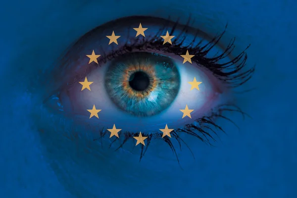 Eye looks through Europe flag background concept macro — Stock Photo, Image