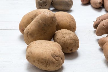 Patateslerin üzerine beyaz ahşap kavram kurulu.