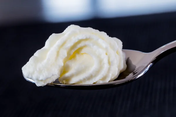 Cream on a spoon macro concept — Stock Photo, Image