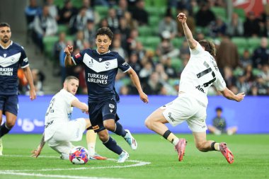 MELBOURNE, AUSTRALIA - 18 Ekim 2025: Auckland FC 'den Lachlan Brook ve Melbourne Victory' den Clerismario Santos Rodrigues, AAMI Park 'ta Melbourne Victory ve Auckland FC arasında oynanan A-League Mens karşılaşmasında top için mücadele ediyorlar.