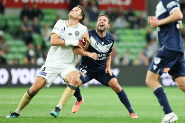 MELBOURNE, AUSTRALIA - 18 Ekim 2025: Auckland FC 'den Louis Verstraete ve Melbourne Victory' den Juan Mata 18 Ekim 2025 'de AAMI Park' ta Melbourne Victory ile Auckland FC arasında oynanan A-League Mens maçında top için yarışıyorlar.