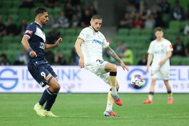MELBOURNE, AUSTRALIA - 18 Ekim 2025: Auckland FC 'den Jake Brimmer ve Melbourne Victory' den Jordi Valadon 18 Ekim 2025 'de AAMI Park' ta Melbourne Victory ve Auckland FC arasında oynanan A-League Mens karşılaşmasında top için yarışıyorlar.