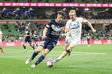 MELBOURNE, AUSTRALIA - 18 Ekim 2025: Auckland FC 'den Francis De Vries ve Melbourne Victory' den Joshua Inserra, Melbourne Mens 'te Melbourne Victory ve Auckland FC arasında 18 Ekim 2025' te AAMI Park 'ta oynanan A-League Mens karşılaşmasında top için yarışıyorlar.