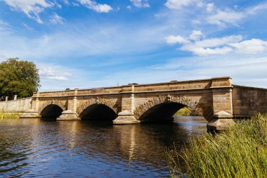 ROSS, AUSTRALYA - 6 Şubat 2025: Tazmanya, Avustralya 'da sıcak bir yaz gününde kırsal Ross kasabasındaki Macquarie Nehri ve Ross Köprüsü manzarası