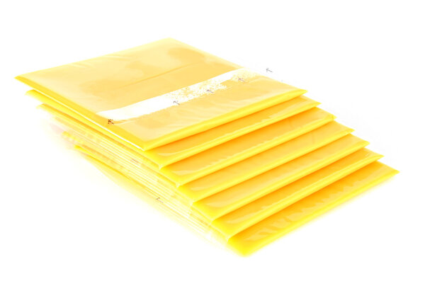 Slices of processed American cheese on white background