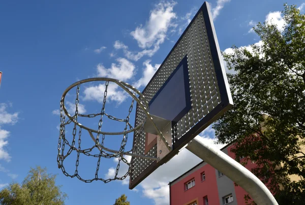 Basketball rim, streetball hoop against blue sky.