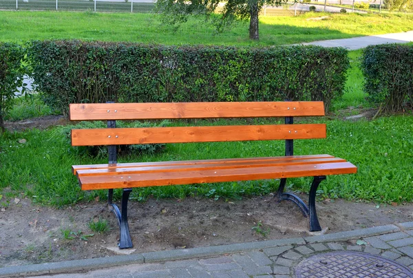 Banco de parque de madeira em um parque de verão — Fotografia de Stock