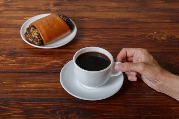 Mão de mulher com xícara de café e croissant — Fotografia de Stock