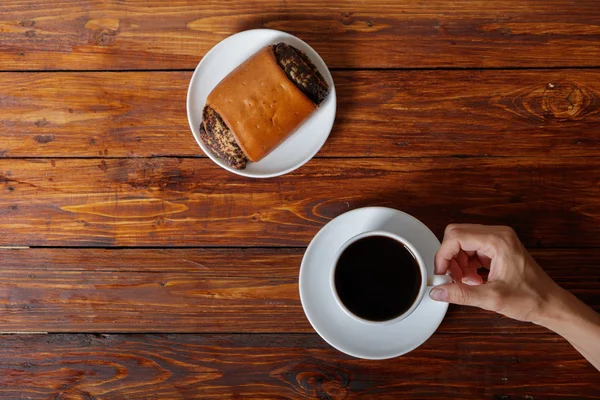 Mano da donna con tazza di caffè e croissant, vista dall'alto — Foto Stock