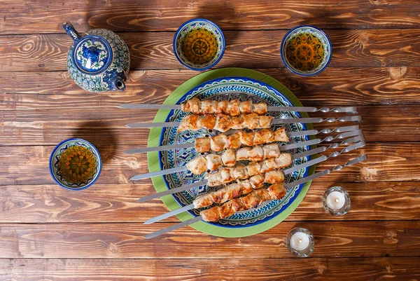 Grilled meat on a ceramic dish and candles in the Uzbek restaurant, Samarkand — Stock Photo, Image