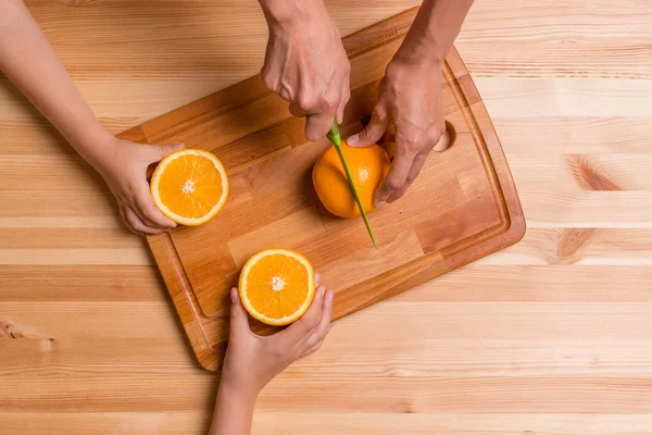 Young woman and her children with orange, top view — Stock Photo, Image