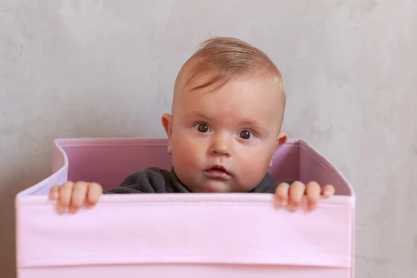 Söt liten baby i rosa rutan — Stockfoto