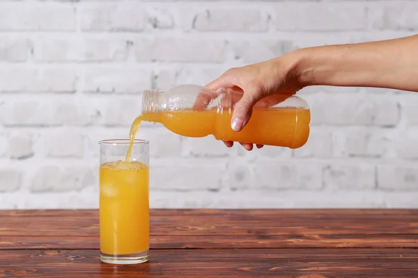 Girl pouring tasty fresh orange juice — Stock Photo, Image