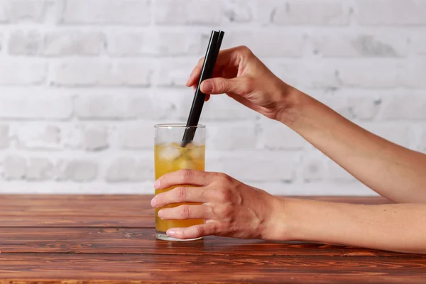 Flicka i restaurangen dricka färsk apelsinjuice från ett sugrör — Stockfoto
