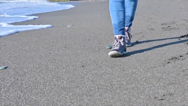 Pernas de mulher nas botas na areia perto da água — Vídeo de Stock