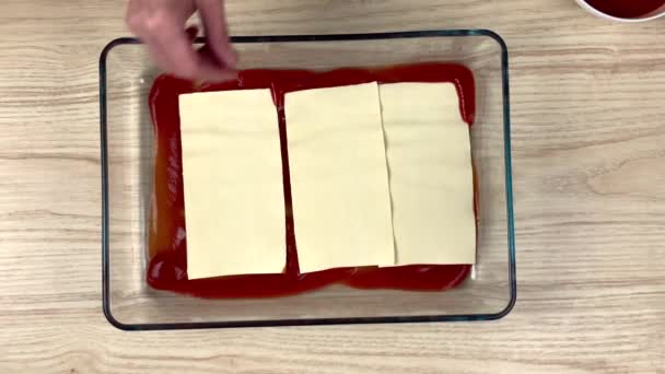 Frau macht Lasagne in der Küche — Stockvideo