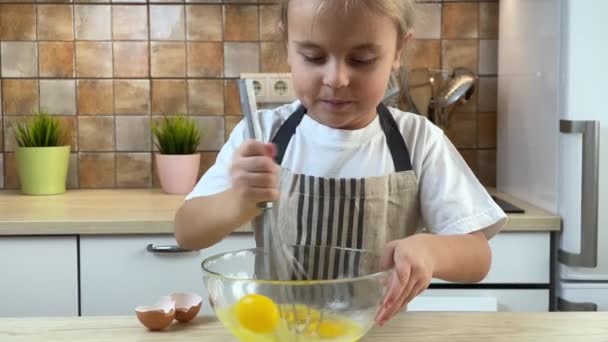 Χαριτωμένο κοριτσάκι αναμιγνύει αυγά σε μπολ — Αρχείο Βίντεο