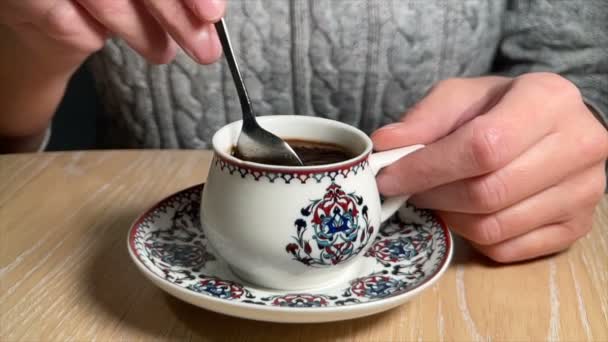 Frau mischt heißen Kaffee in Tasse mit traditionellem arabischen Ornament — Stockvideo