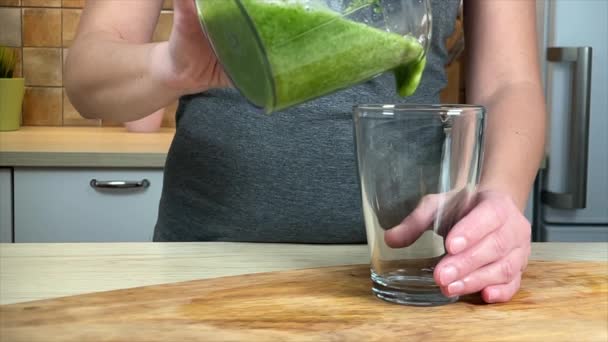 Mujer verter fresco verde plátano espinaca smoothie a vidrio — Vídeos de Stock