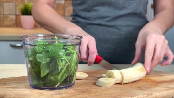 Frau bereitet Smoothie mit Banane und Spinat zu — Stockvideo