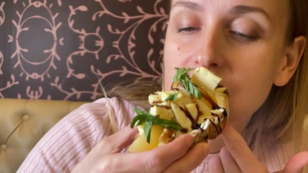 Portrét ženy jíst vegetariánský sendvič v kavárně — Stock video
