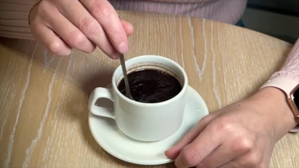 Vrouw die koffie mengt in witte beker — Stockvideo