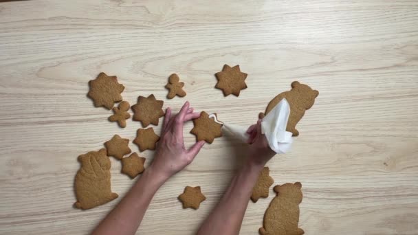 Woman decorating fresh gingerbread on the kitchen — Stock Video