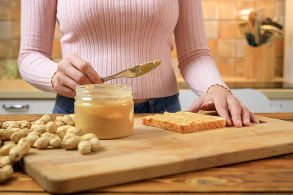 Wanita menyiapkan sandwich dengan selai kacang Stok Foto Bebas Royalti