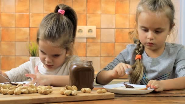 Niñas preparando sándwich con mantequilla de maní y comerlo — Vídeo de stock