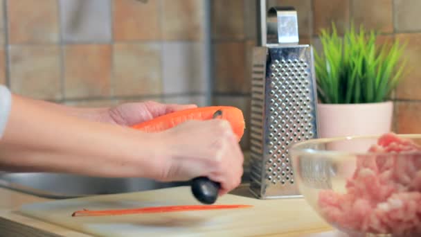 Mulher preparando cenoura para cozinhar na cozinha — Vídeo de Stock