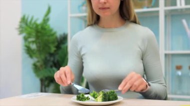 Kafede brokoli yiyen vejetaryen kadın.