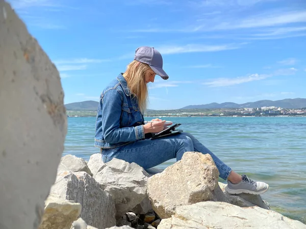 Donna che disegna su tablet vicino alla costa del mare — Foto Stock