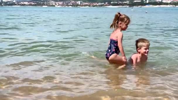 Ευτυχισμένα παιδιά που παίζουν και κολυμπούν στη θάλασσα — Αρχείο Βίντεο