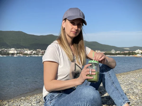 Mulher bebendo smoothie desintoxicação verde na praia — Fotografia de Stock