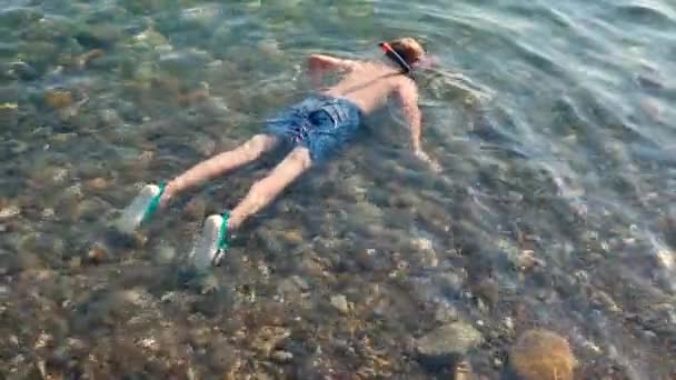 Kleiner Junge schnorchelt am sonnigen Tag im Meer in Küstennähe — Stockvideo