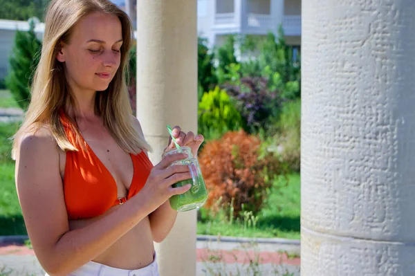 Mulher loira de biquíni bebendo smoothie verde no resort — Fotografia de Stock