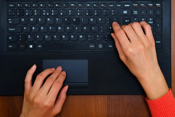 Manos escribiendo texto en un teclado portátil — Foto de Stock