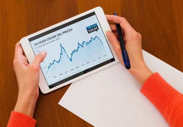 Female holding tablet with oil chart — Stock Photo, Image