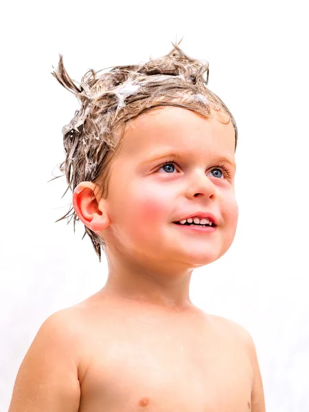 Cute little boy in bathroom with foam on head — Stock Photo, Image