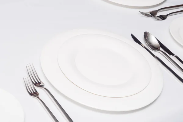 Beyaz tabaklar çatal bıçak seti ile — Stok fotoğraf