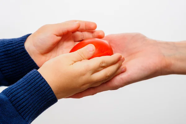 Mano de niño sosteniendo huevo de Pascua rojo — Foto de Stock