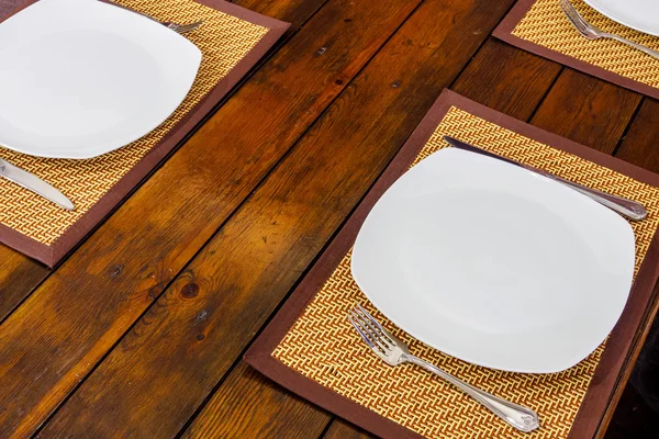 Bord en bestek op houten tafelblad bekijken. — Stockfoto