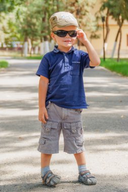 Güneş gözlüklü küçük çocuk.