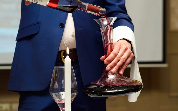 Сомелье наливает вино в графин в винный погреб — стоковое фото